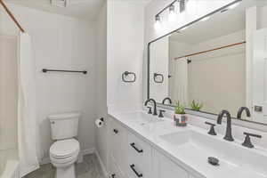 Full hall bath with double vanity and shower.