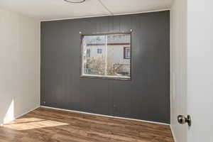 Empty room featuring baseboards and wood finished floors