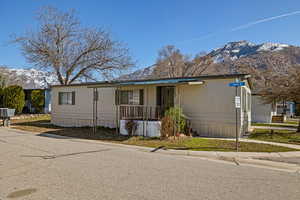 Manufactured / mobile home featuring a mountain view and covered porch