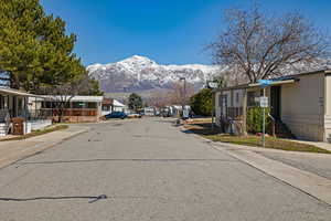 View of road with traffic signs, sidewalks, curbs, a residential view, and a mountain view