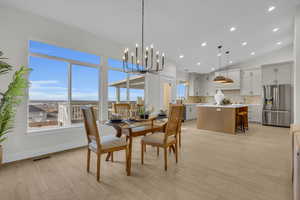 Dining space featuring visible vents, baseboards, recessed lighting, vaulted ceiling, and light wood-style floors