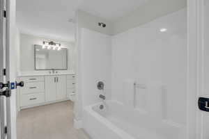 Bathroom featuring visible vents, toilet, tile patterned floors, vanity, and  shower combination