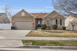 Ranch-style house with fence, a garage, driveway, and stucco siding