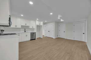 Second Kitchen with light wood-type flooring, a sink, stainless steel appliances, white cabinets, and light countertops