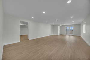 Unfurnished room with light wood finished floors, recessed lighting, french doors, and baseboards