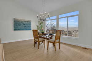 Dining room featuring a notable chandelier, a mountain view, light wood-type flooring, and baseboards