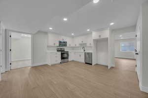 Kitchen with light wood-type flooring, recessed lighting, stainless steel appliances, and light countertops