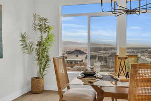 Dining area with a mountain view, baseboards, a notable chandelier, and wood finished floors