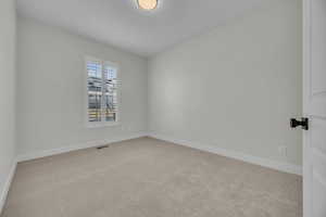 Empty room with visible vents, baseboards, and carpet floors