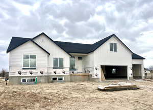 View of front facade featuring board and batten siding and roof with shingles