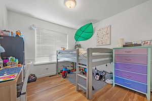 Bedroom with wood finished floors and baseboards