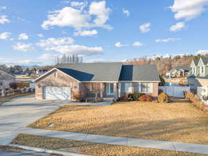 Ranch-style house featuring fence, roof with shingles, concrete driveway, an attached garage, and brick siding