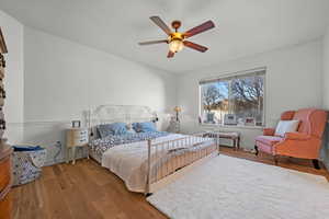Bedroom featuring baseboards, wood finished floors, and a ceiling fan