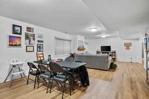 Dining room with a textured ceiling and light wood finished floors
