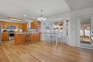 Kitchen featuring brown cabinetry, light wood-style flooring, stainless steel appliances, and light countertops