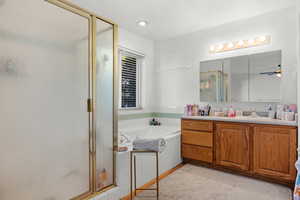 Bathroom with a shower stall, vanity, a garden tub, and ceiling fan
