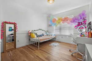 Bedroom with baseboards and wood finished floors