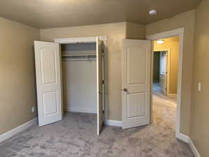 Unfurnished bedroom featuring baseboards, a closet, and carpet floors