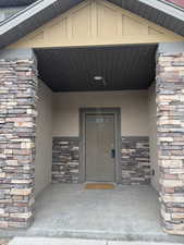 View of exterior entry featuring stone siding and stucco siding