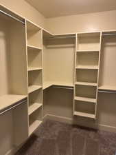 Walk in closet featuring dark carpet