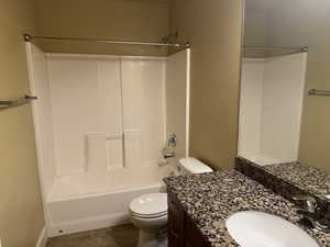 Bathroom with tile patterned flooring, toilet, shower / bathtub combination, and vanity