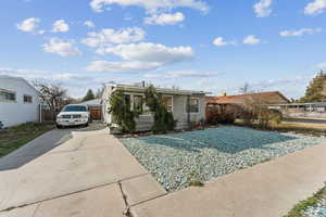 View of front of property featuring concrete driveway and fence