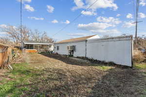 Rear view of property with a wall mounted air conditioner and fence