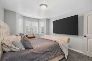 Bedroom featuring baseboards, new carpet, and bay window