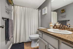 Full bath featuring visible vents, toilet, vanity, and tile patterned flooring