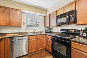 Kitchen with a sink and black appliances