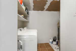 Washroom with laundry area, tile patterned floors, and washer and clothes dryer