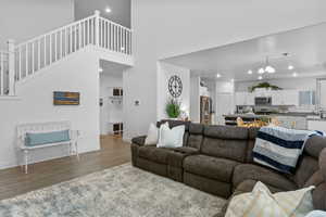 Living area featuring recessed lighting, baseboards, wood finished floors, and a towering ceiling
