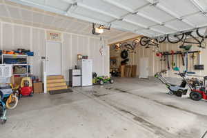 Garage with a garage door opener and freestanding refrigerator