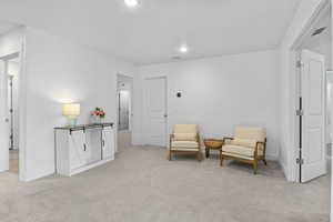 Sitting room featuring light carpet, visible vents, recessed lighting, and baseboards