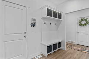 Mudroom with visible vents, light wood-style flooring, and baseboards