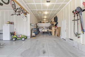 Garage with a garage door opener and freestanding refrigerator