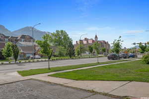 View of road featuring sidewalks, a mountain view, a residential view, and street lights