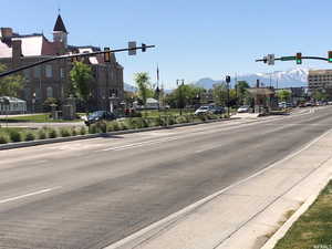 View of street featuring sidewalks, a mountain view, traffic lights, and curbs