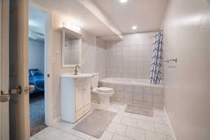Full bath featuring toilet, tiled shower / bath, recessed lighting, vanity, and tile patterned flooring