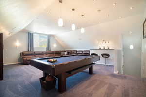 Playroom over the garage with billiards, vaulted ceiling, carpet floors, and baseboards