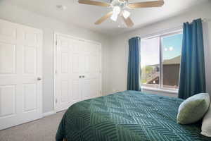 Bedroom featuring ceiling fan, carpet flooring, and a closet