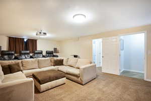 Carpeted recreation room with theatre seating arrangements