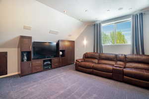 Living area over the garage with recessed lighting, lofted ceiling, and carpet floors