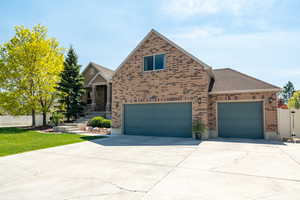 View of front facade featuring concrete driveway, an attached 3rd car garage, fully fenced, and brick siding