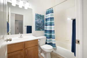 Full bathroom featuring toilet, tile patterned flooring, shower / bathtub combination with curtain, and vanity