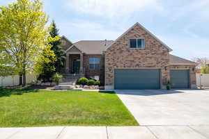 Craftsman house with concrete driveway, roof with Asphalt shingles, brick siding, a front lawn, and a garage