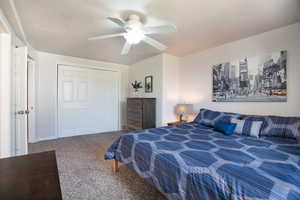 Carpeted bedroom main suite in basement with a closet and ceiling fan
