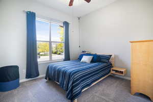 Bedroom featuring a ceiling fan, carpet flooring, and baseboards