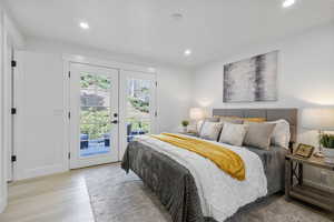 Primary bedroom with recessed lighting, french doors, access to exterior deck and en-suite bathroom. (located at back of home)