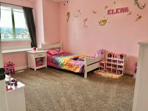 Bedroom featuring carpet and baseboards